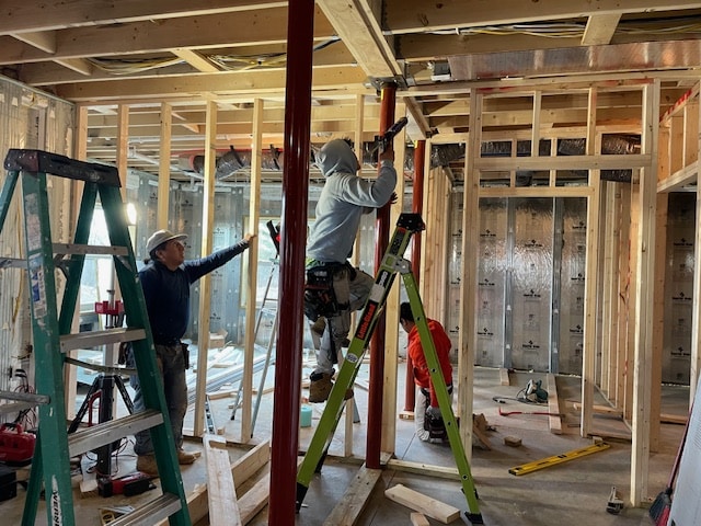Commonwealth Maintenance team working on framing and drywall installation during a basement renovation, demonstrating their expertise in construction